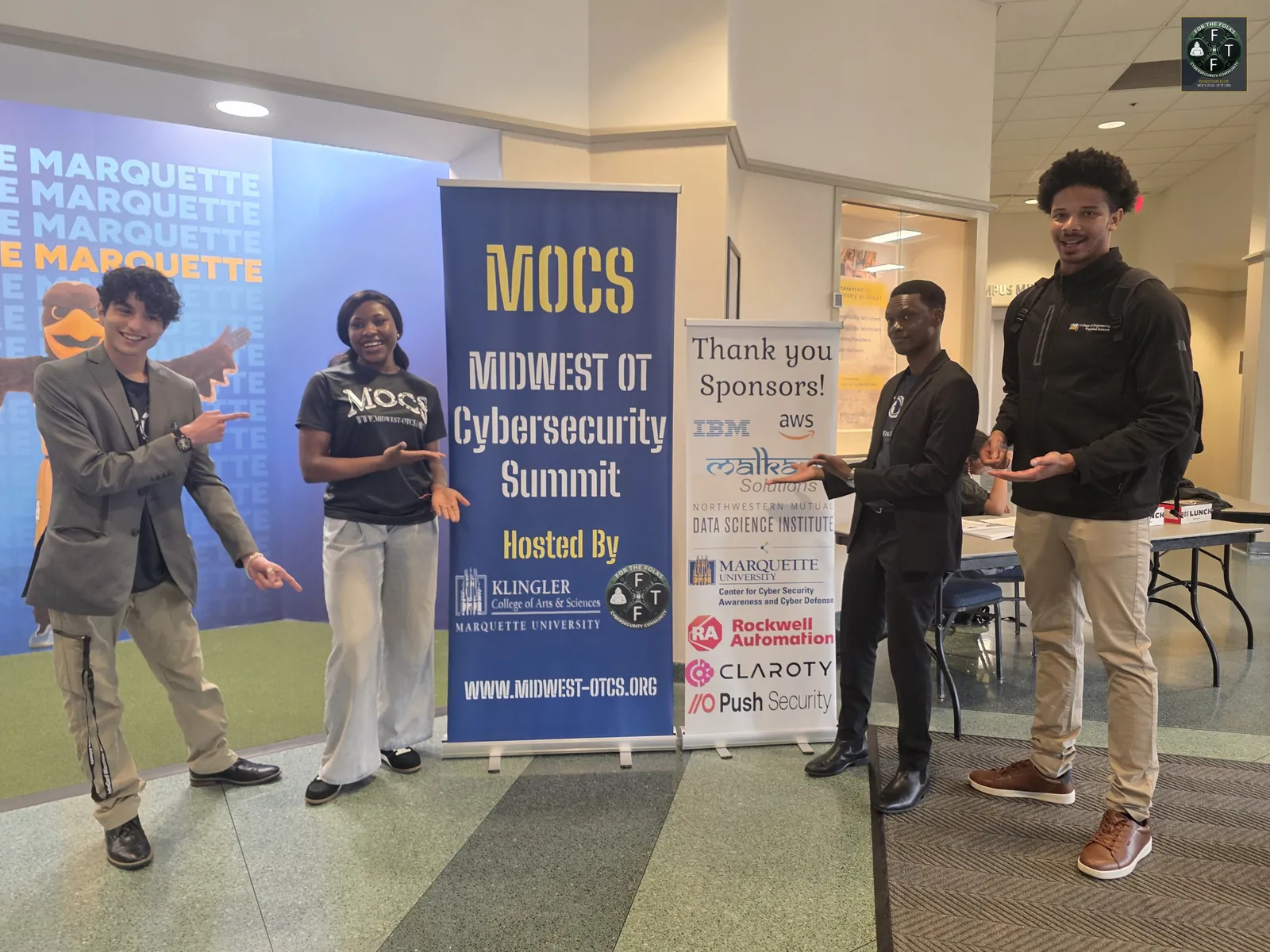 MOCS team and volunteers next to the sponsor banner